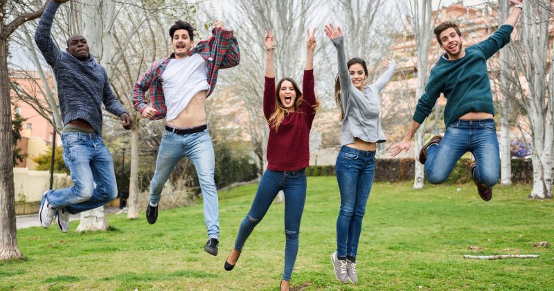 Group of multi-ethnic young people jumping together outdoors